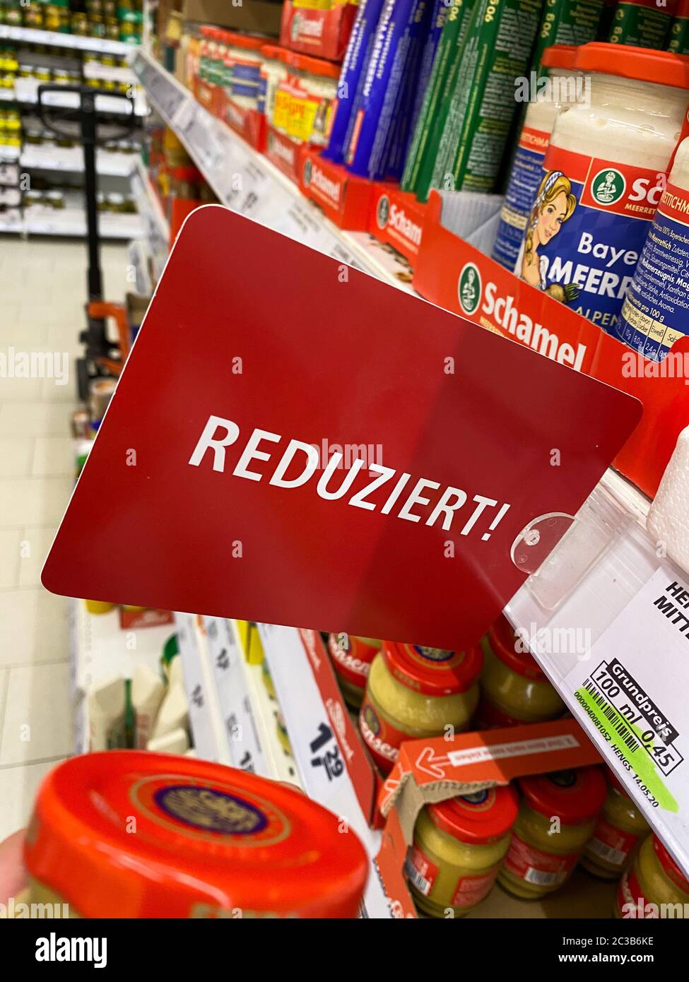 Tönisvorst, Germany - June 18. 2020: View on isolated red reduced price (reduziert) sign at german supermarket shelf Stock Photo