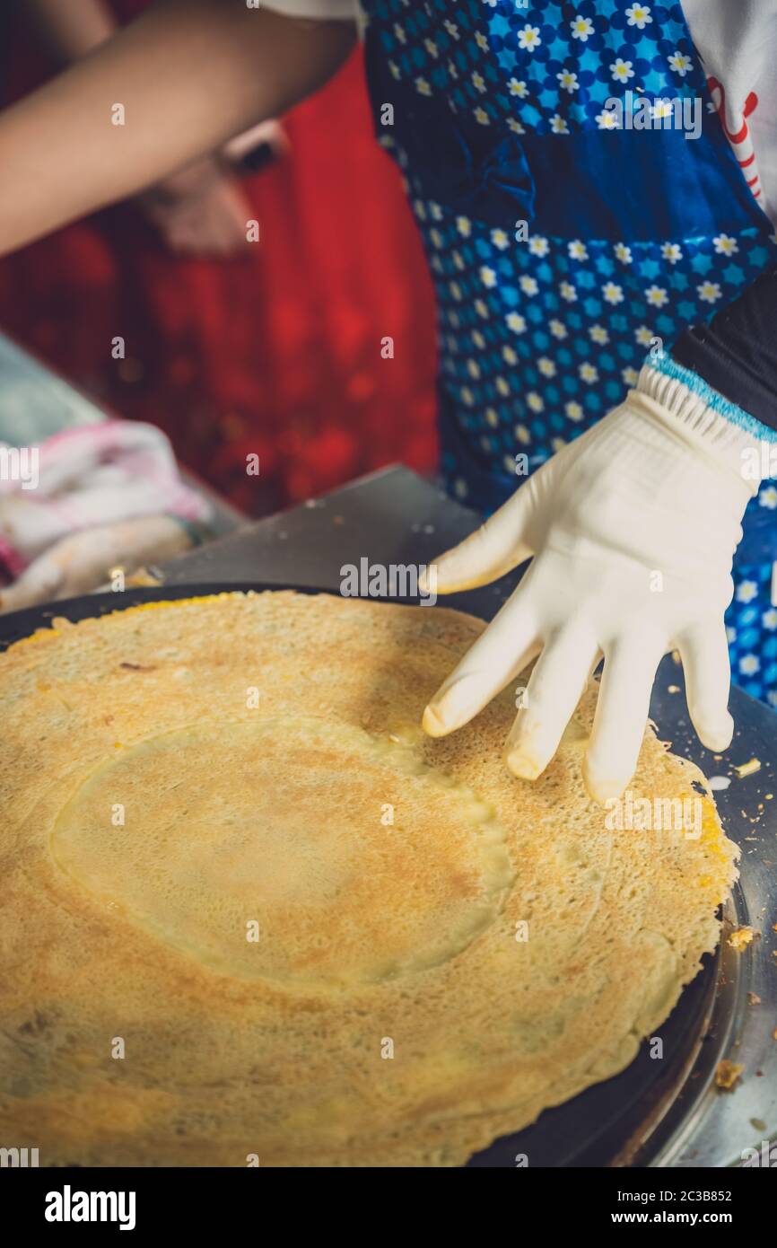 Woman making savoury egg pancakes in a small local street outlet bakery in Yichang town, China Stock Photo