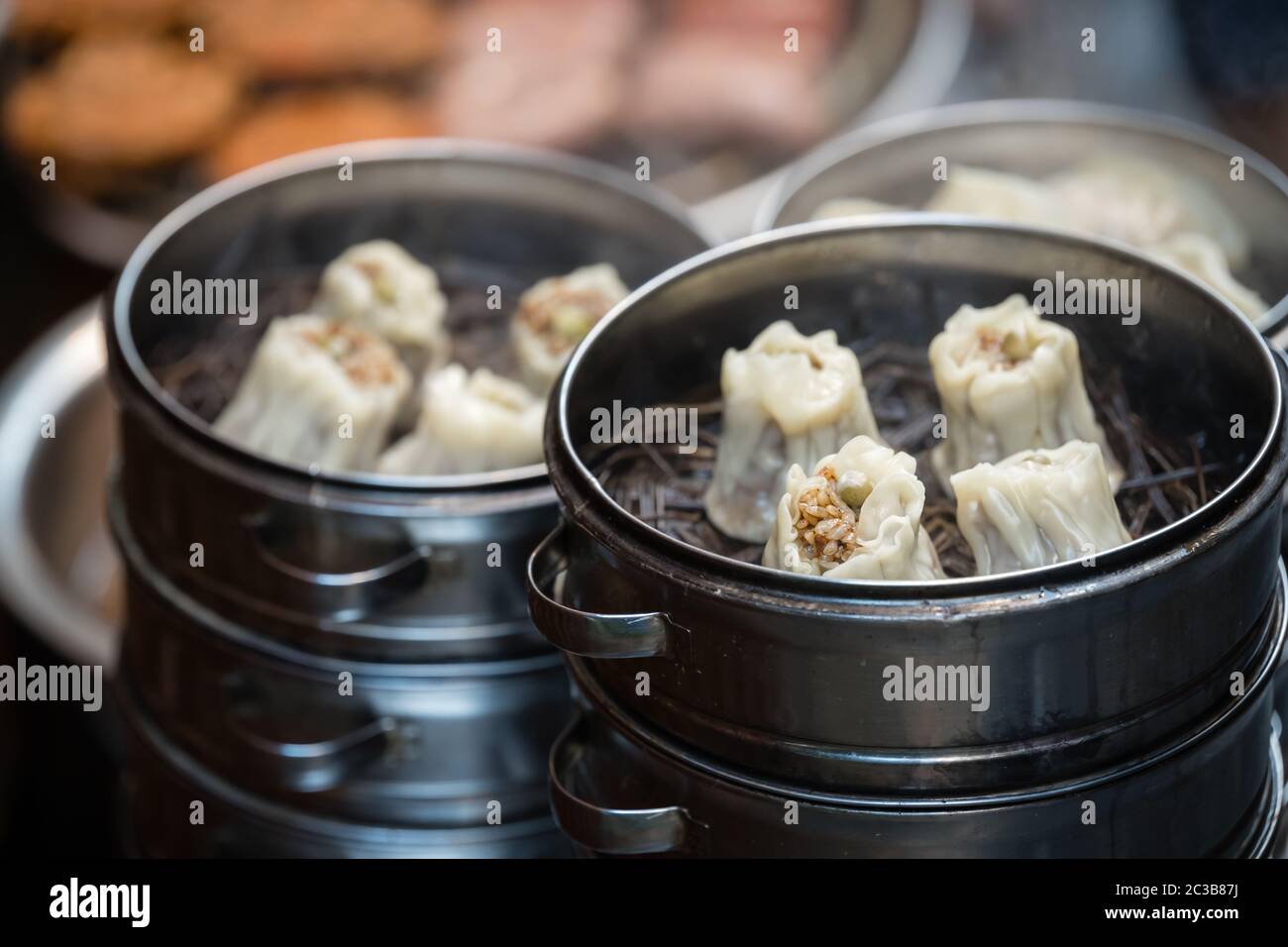 Delicious traditional chinese dumplings steamed and filled with pork meat, prepared on hot steam, China Stock Photo