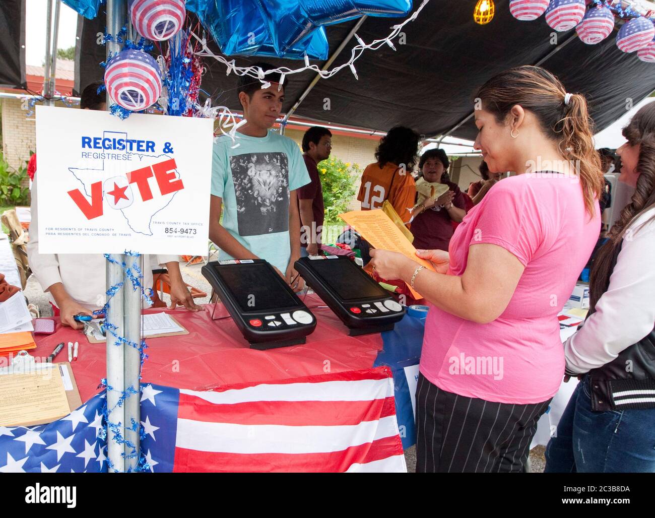 Austin Texas USA, October 6, 2012.: Volunteers man voter registration booth at Catholic Church festival. The booth includes demonstrations of the electronic voting machines used in Texas   ©MKC / Daemmrich Photos Stock Photo