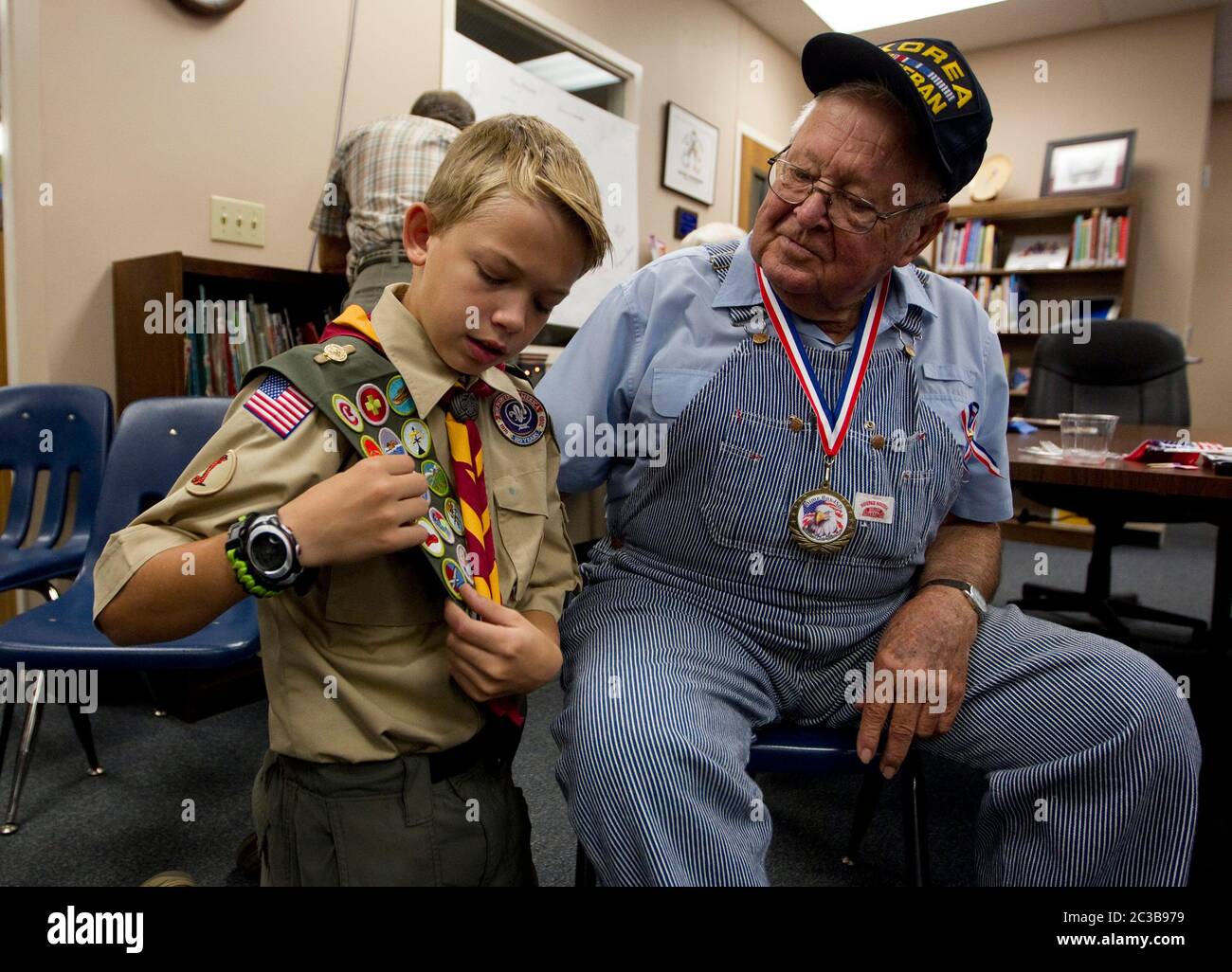 Dime Box Texas USA, November 12 2012:13-year-old Boy Scout shows his merit badges to a Korean War veteran during a Veteran's Day celebration at a school in the small town. ©MKC / Daemmrich Photos Stock Photo
