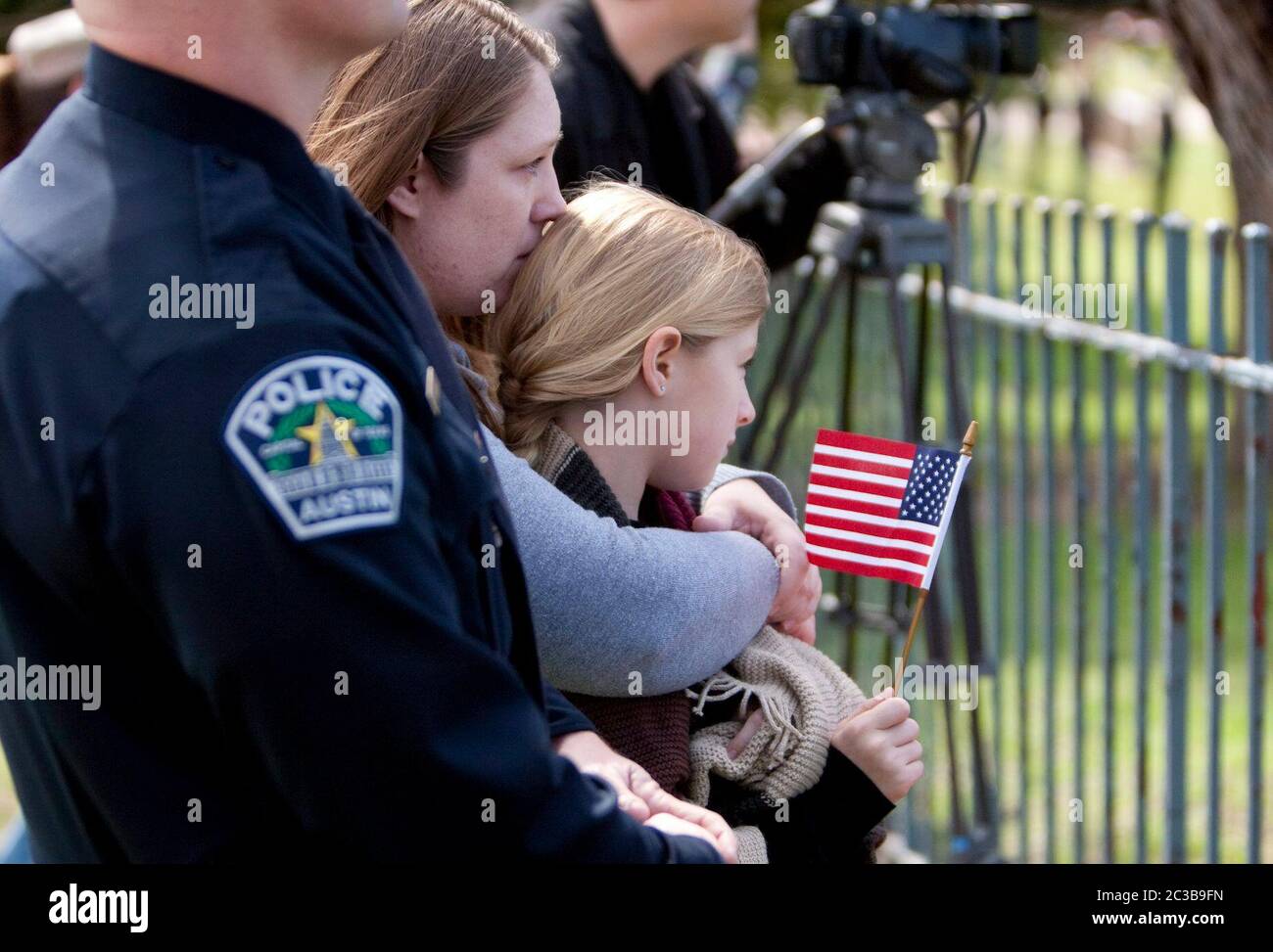 Austin Texas USA, February 12, 2013: A woman hugs her daughter, holding a small American flag, as they pay respects to former Navy SEAL Chris Kyle during his burial at the Texas State Cemetery. Kyle served four tours of duty as a sniper during the Iraq war, and wrote a popular book about his experiences there. He was fatally shot by a fellow Iraq war veteran at a gun range in Glen Rose, Texas on February 2. ©Marjorie Kamys Cotera/Daemmrich Photography Stock Photo