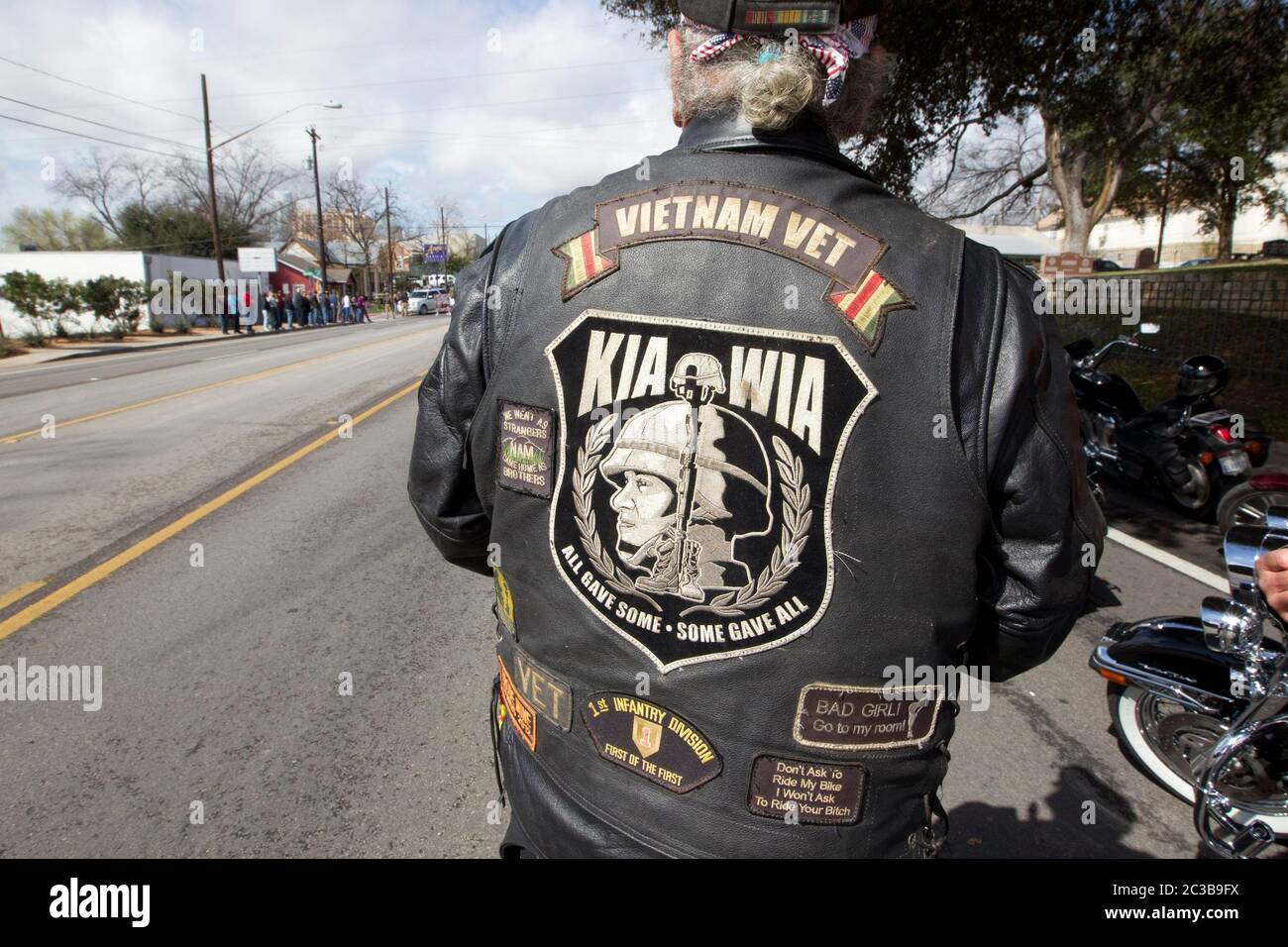 Austin Texas USA, February 12, 2013: Man wearing a Vietnam veteran jacket joins other mourners paying respects to former Navy SEAL Chris Kyle as his funeral cortege passes on its way to his burial at the Texas State Cemetery. Kyle served four tours of duty as a sniper during the Iraq war, and wrote a book about his experiences there. He was fatally shot by a fellow Iraq war veteran at a gun range in Glen Rose, Texas on February 2. ©Marjorie Kamys Cotera/Daemmrich Photography Stock Photo