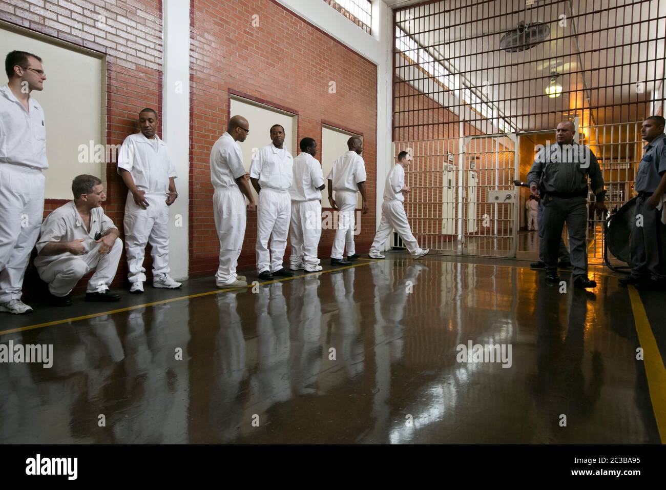 Rosharon Texas USA, August 25 2014: Uniformed male inmates, students of the Southwestern Baptist Theological Seminary program inside Darrington prison, line up in a hallway monitored by prison guards before entering their classroom.  ©Marjorie Kamys Cotera/Daemmrich Photography Stock Photo