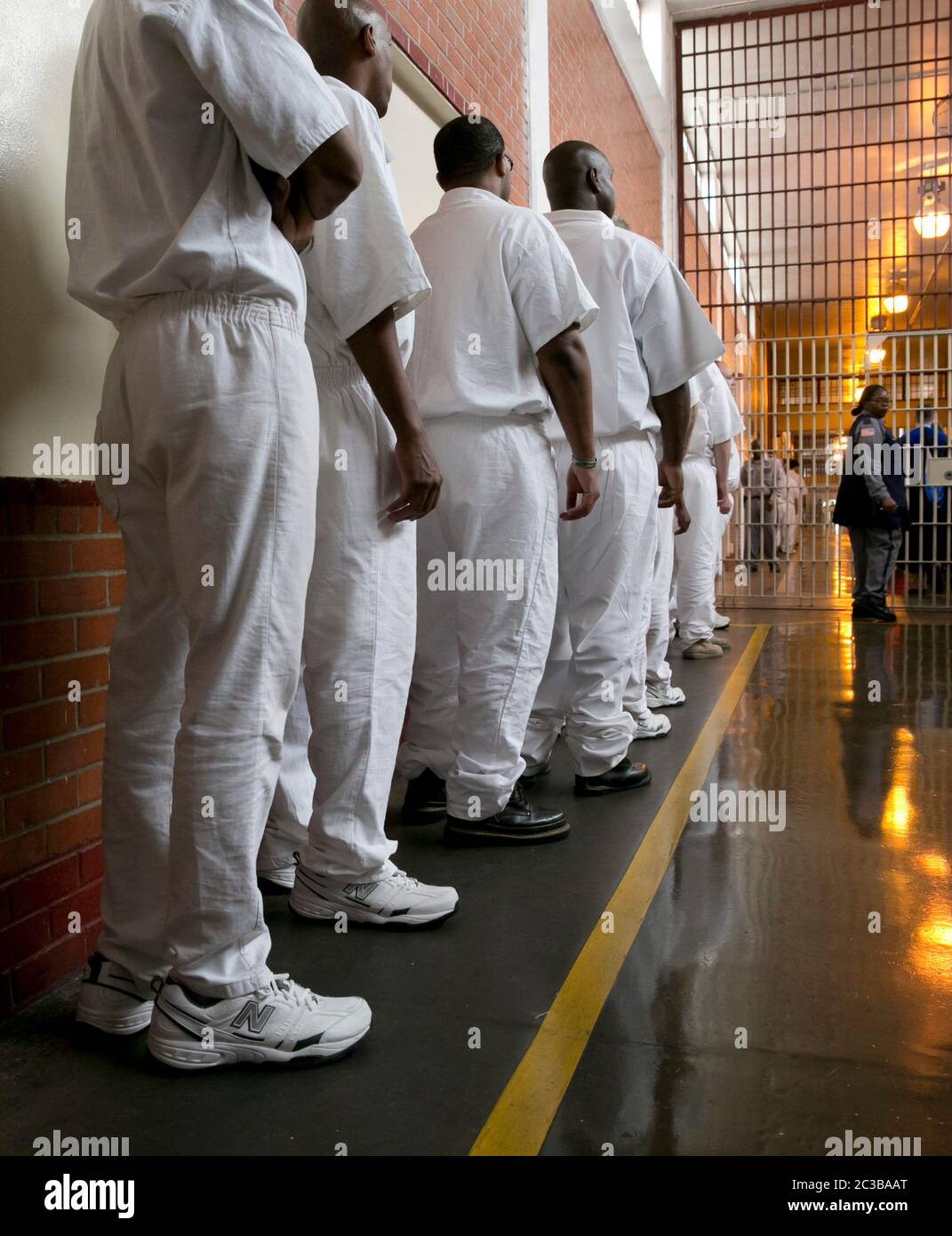 Rosharon Texas USA, August 25 2014: Uniformed male inmates, students of the Southwestern Baptist Theological Seminary program inside Darrington prison, line up in a hallway monitored by prison guards before entering their classroom.  ©Marjorie Kamys Cotera/Daemmrich Photography Stock Photo