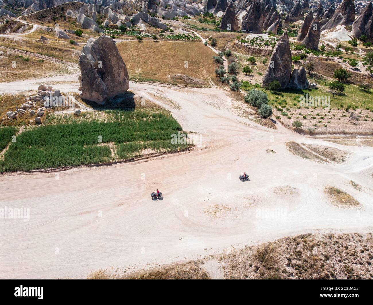 Aerial view of Goreme National Park, Tarihi Milli Parki, Turkey. The typical rock formations of Cappadocia. Tourists on quads Stock Photo