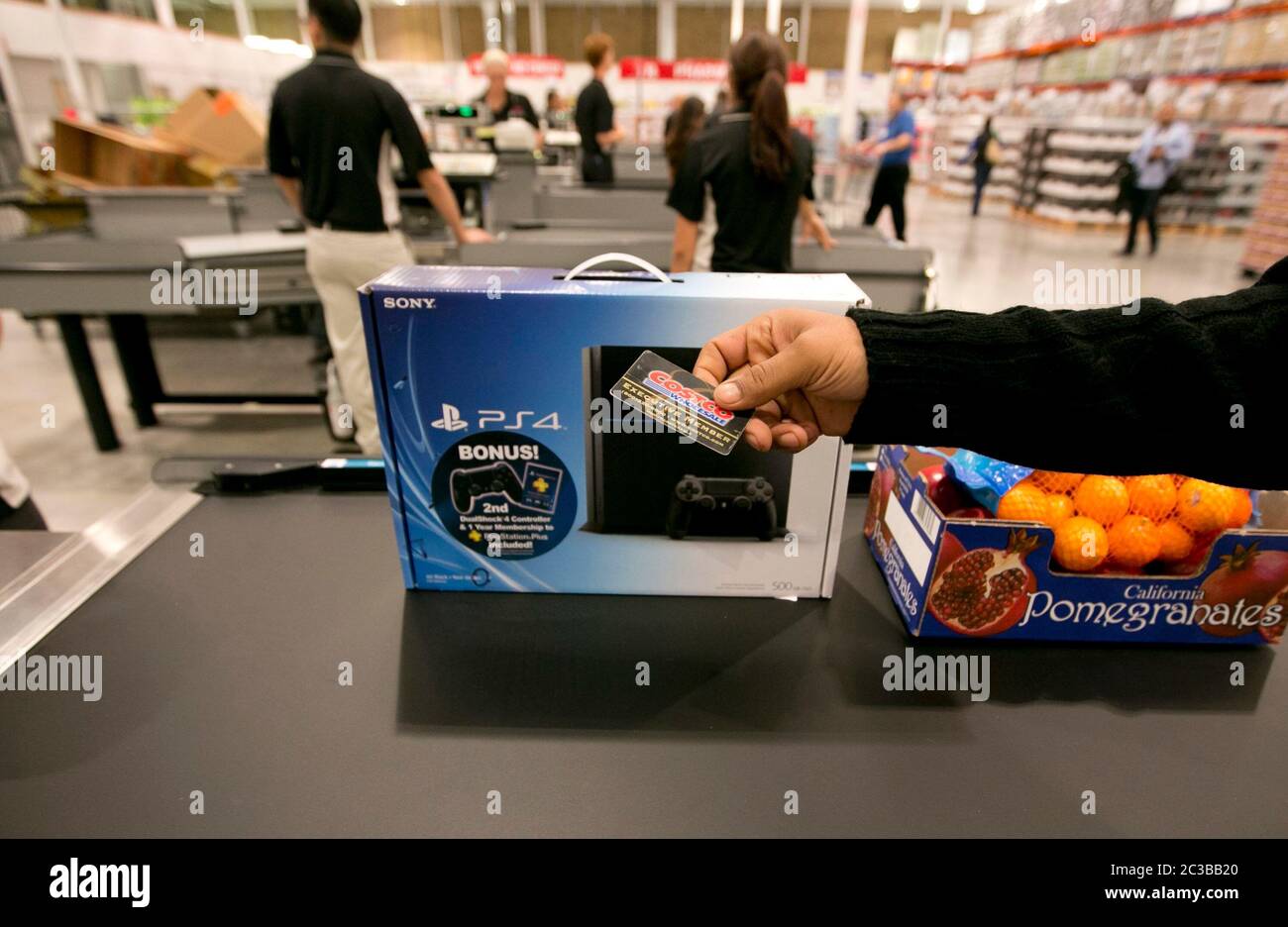 Cedar Park Texas USA, November 22 2013:Customer hands membership card to cashier at checkout line of newly opened Costco warehouse club in a fast-growing Austin suburb.   ©Marjorie Kamys Cotera/Daemmrich Photography Stock Photo