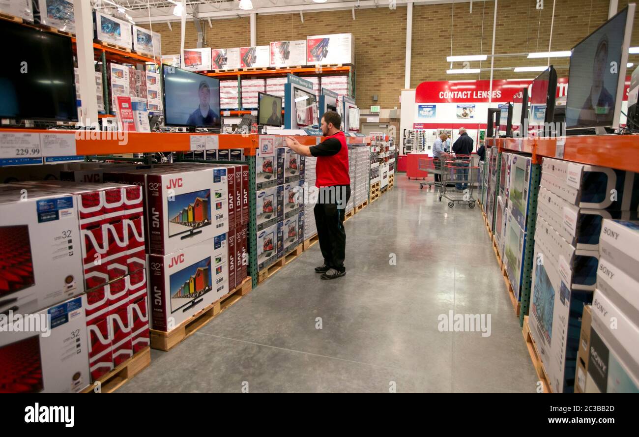 Cedar Park Texas USA, November 11 2013: Costco warehouse club employee keeps stacks of electronics looking tidy at newly opened store in a fast-growing Austin suburb. ©Marjorie Kamys Cotera/Daemmrich Photography Stock Photo