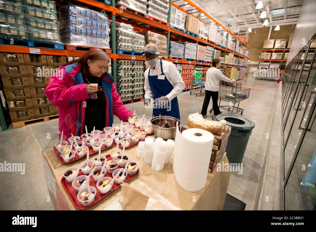 Cedar Park Texas USA, November 22 2013: Female shopper helps herself to a free sample of cake at a newly opened Costco warehouse club in a fast-growing Austin suburb.   ©Marjorie Kamys Cotera/Daemmrich Photography Stock Photo