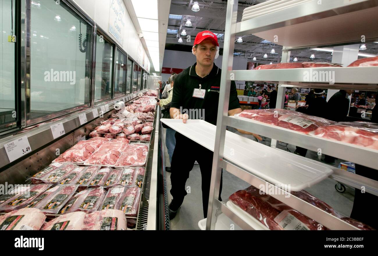 Costco Employee at Costco warehouse club stock fresh meat items at