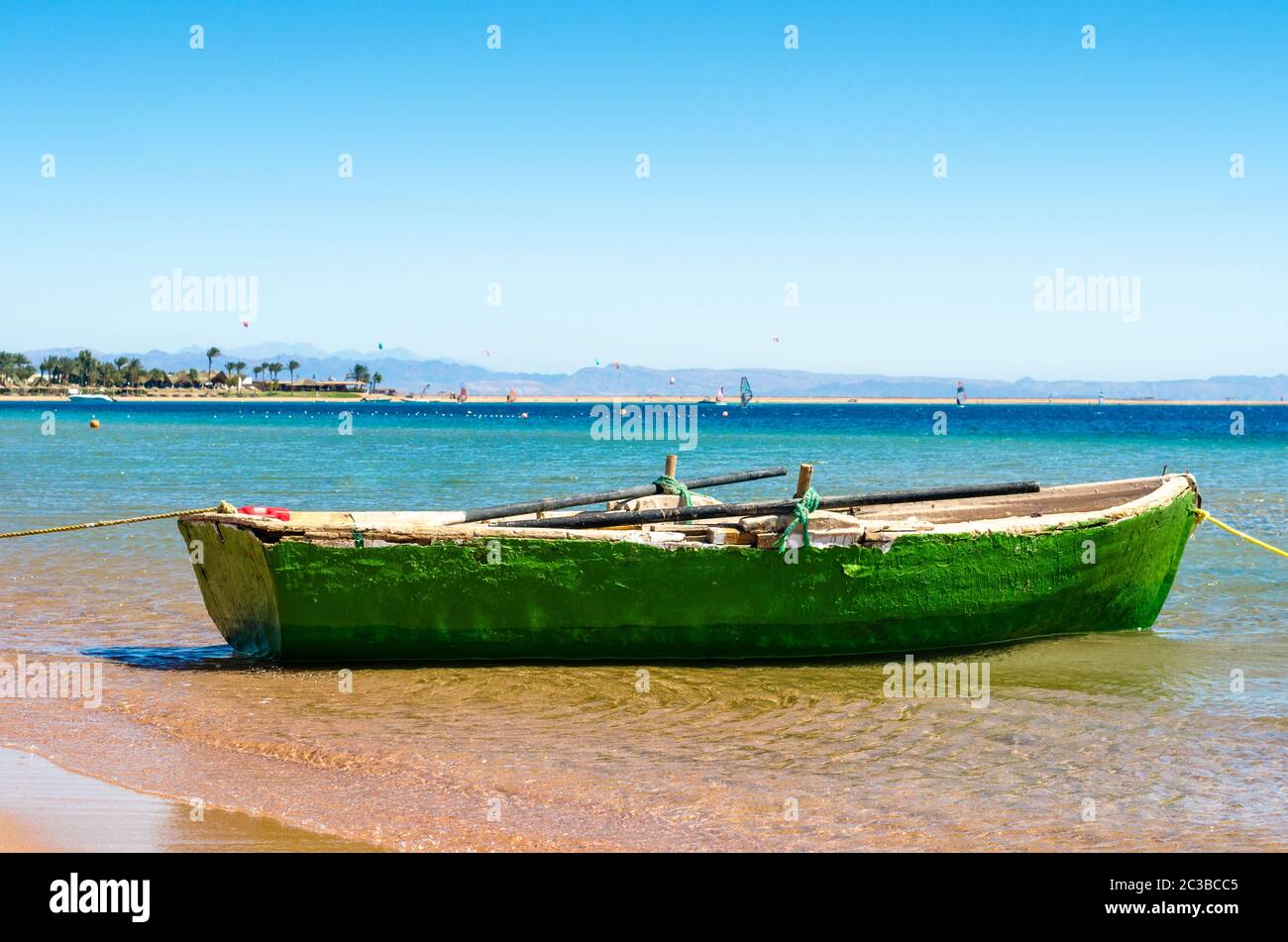 Old wooden fishing boat in the sea on the background of the beach with ...