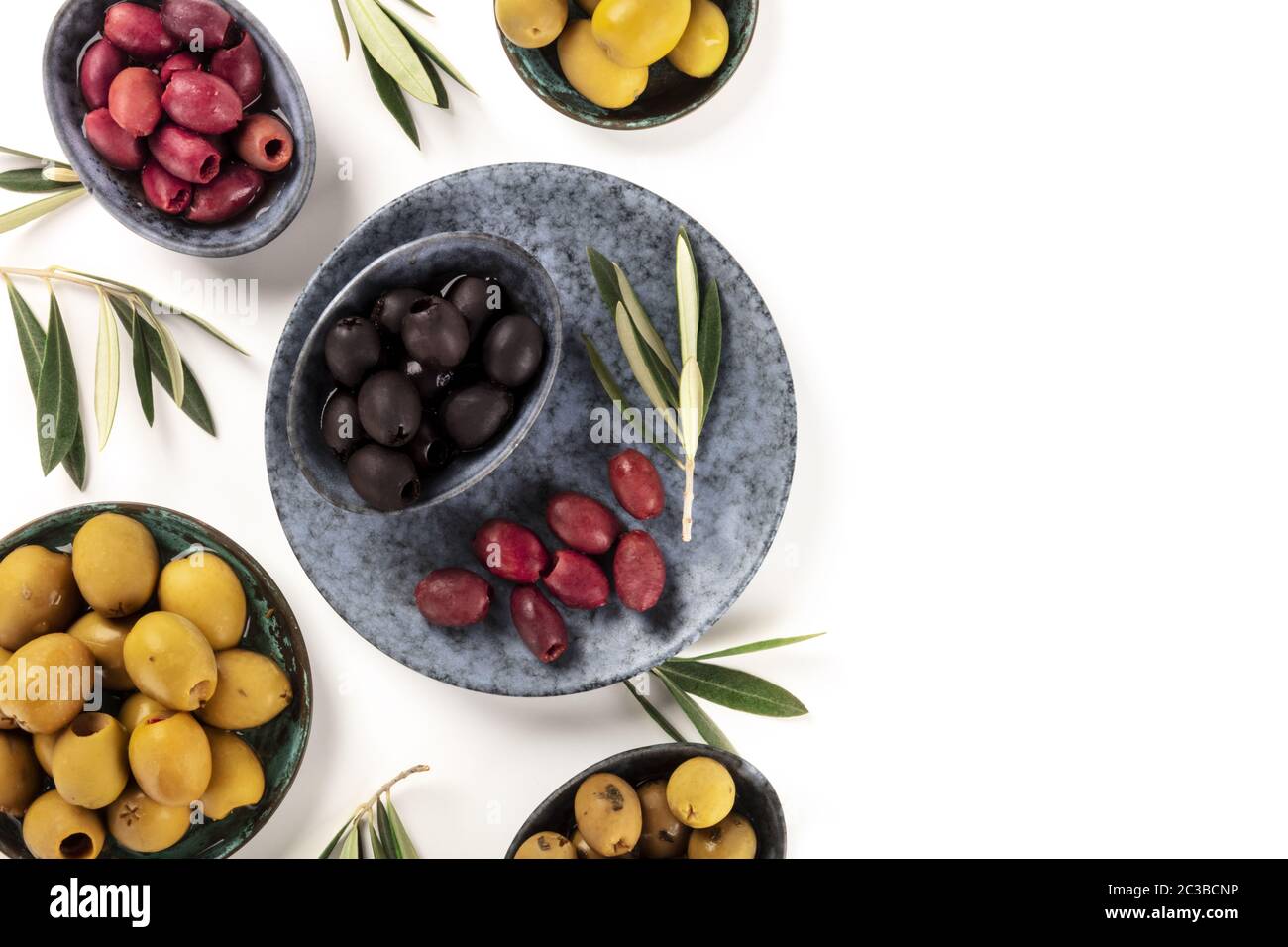 Olives variety on a white background, shot from the top. Black, green and red olives of various sizes, with copy space Stock Photo