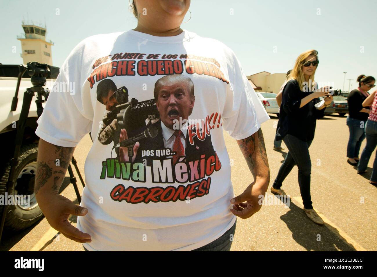 Laredo Texas USA, July 23rd, 2015: Donald Trump in Laredo - Woman  in a group protesting the arrival of Republican presidential nominee hopeful Donald Trump wears a t-shirt that includes insults to Trump and images of Mexican drug trafficker El Chapo Guzman. Trump, who has been critical of Mexican immigrants and U.S. immigration control, traveled to the town on the U.S.-Mexico border for a campaign event.  ©Marjorie Kamys Cotera/Daemmrich Photography Stock Photo
