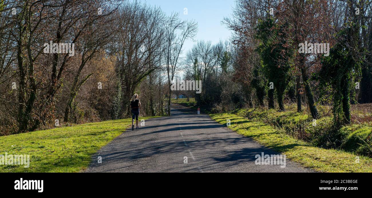 sporty woman on the small road at winter season Stock Photo