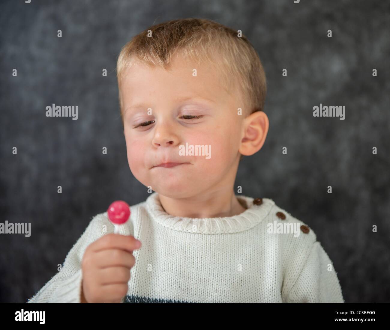a cute child is eating a lollipop Stock Photo