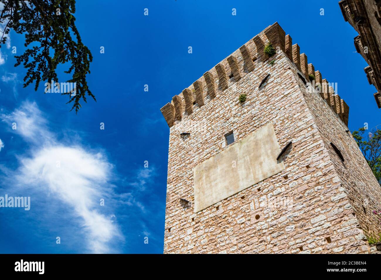Stone Merlon The tower and the medieval walls, in stone and brick, with merlon. In ...
