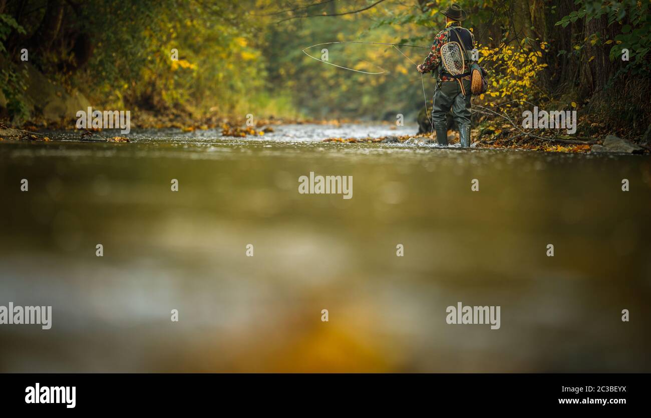 Man fishing on a mountain river with a ultralight spinning using fishing  wobblers. He got his hook hooked for something Stock Photo - Alamy