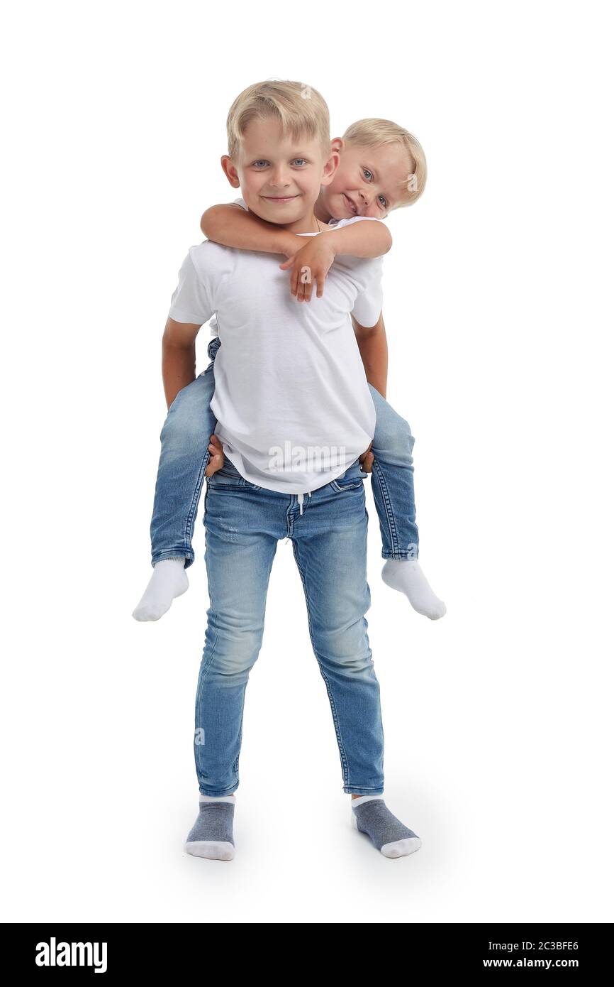 Friendly family. Older brother is holding behind the back younger boy, standing isolated on a