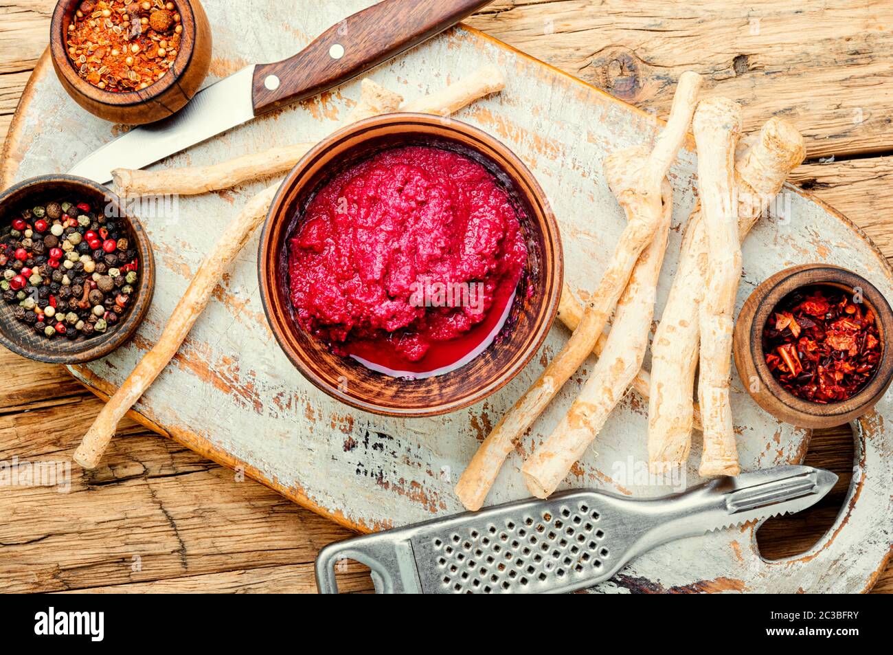 Homemade spicy horseradish seasoning sauce on wooden table.Fresh grated horseradish roots Stock