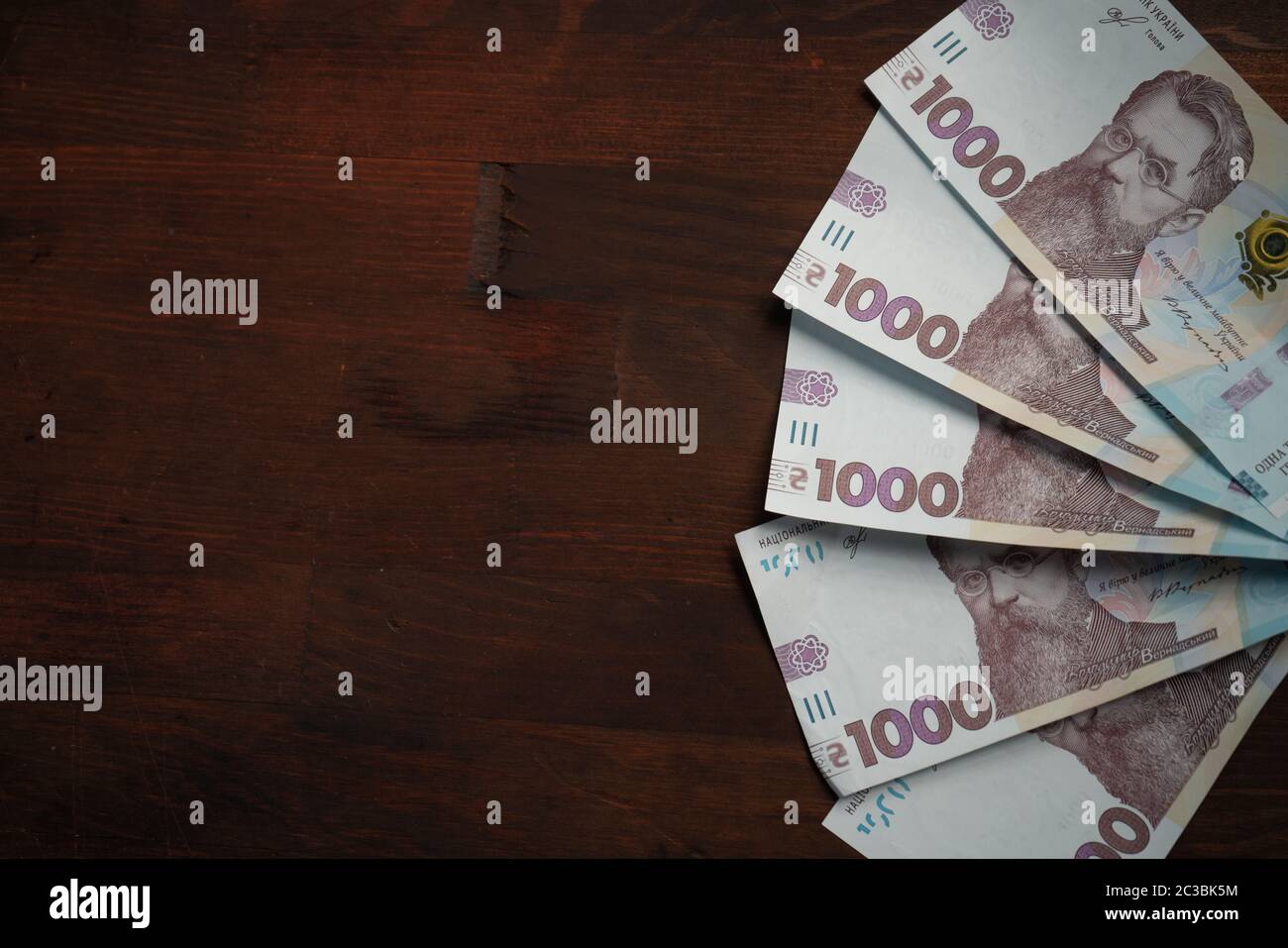 Fun from new Ukrainian banknotes face value 1000 hryvnia. Paper money on wooden background with copy cpace or textspace at left side. Close up shot Stock Photo