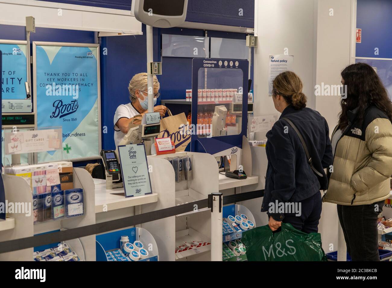 A woman working in Boots wears a face mask at the till in Boots, Cambridge,  UK. 18/06/20 Stock Photo - Alamy
