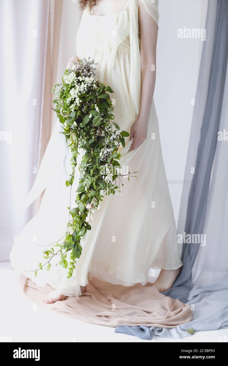 Bride in delicate gown with bouquet of small white flowers Stock Photo