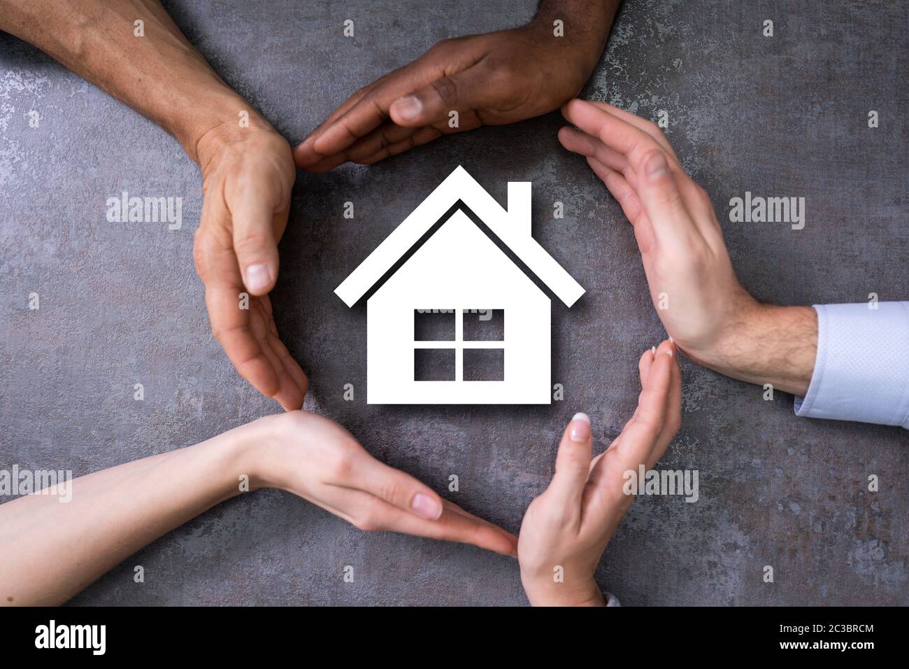Group Of Persons Protecting Cutout House Shape Stock Photo