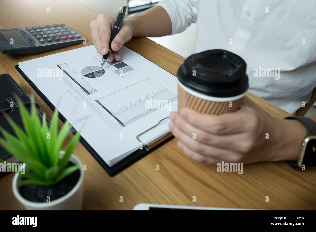 Paperwork Singing businessman going through some paperwork and signing a document at desk ...
