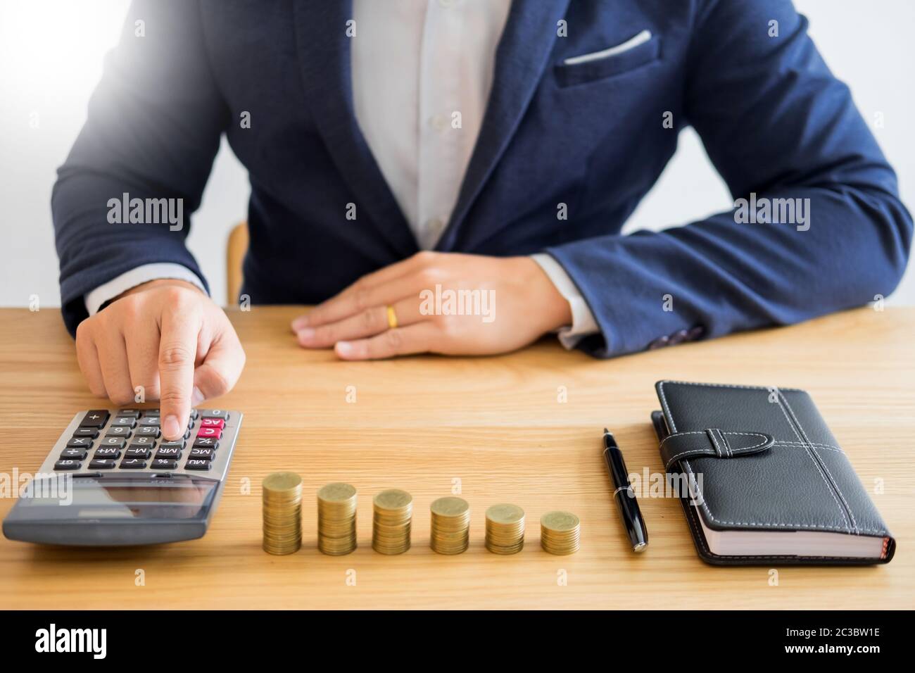 Business accounting man hands working stacking coin the calculator,  calculating, financial investment planning and saving concept Stock Photo -  Alamy