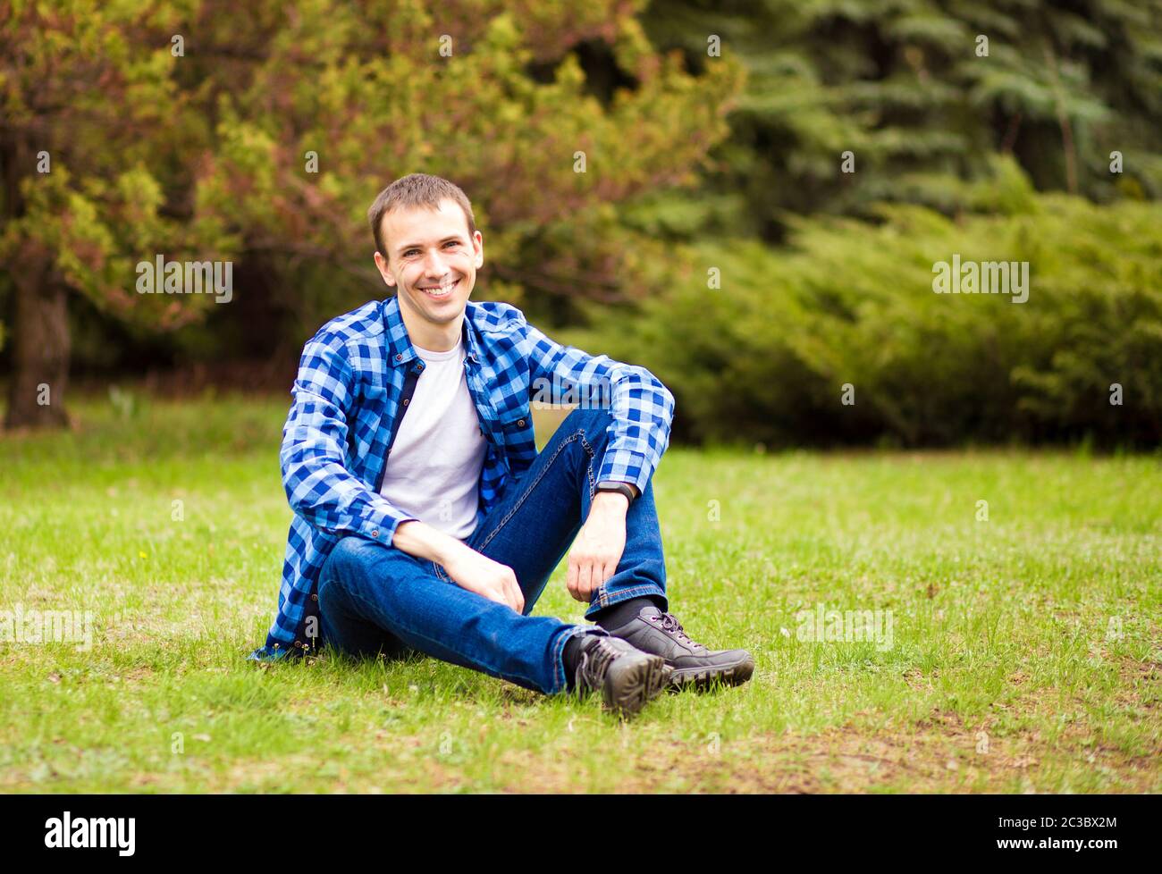 Young man relaxing on grass in park Stock Photo