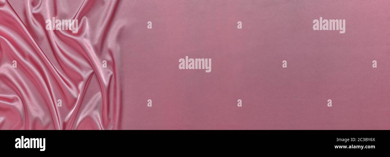 Abstract background from pink silk or satin. Luxury fabric texture with ...