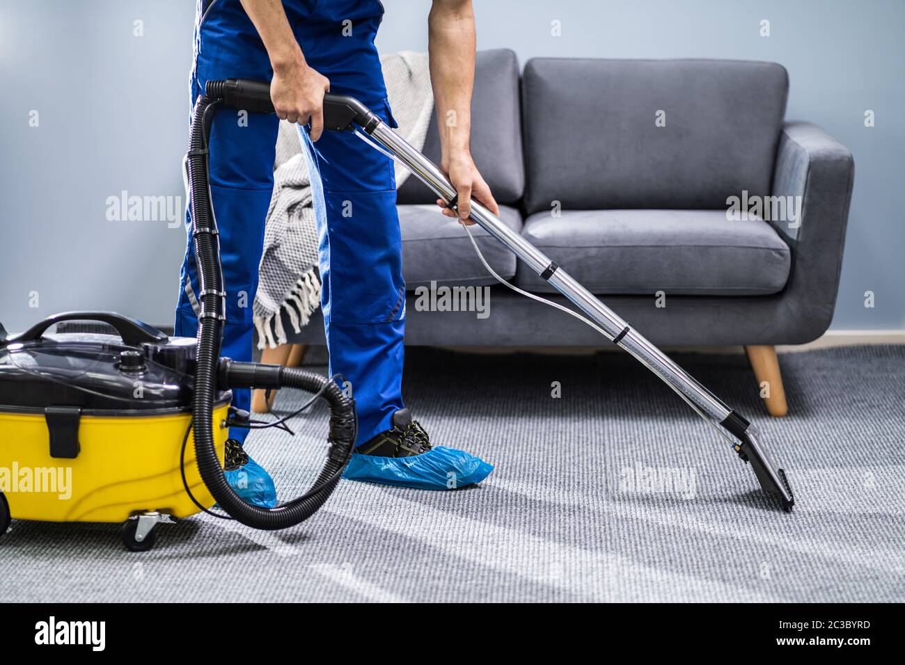 Photo Of Janitor Cleaning Carpet With Vacuum Cleaner Stock Photo