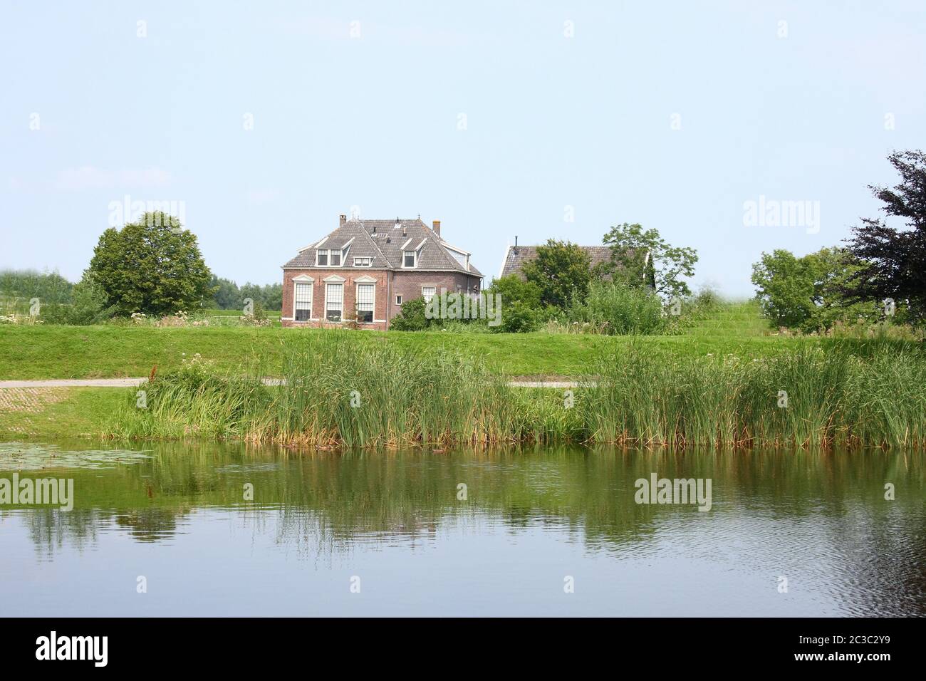 Lonely old House, with a body of water in the foreground Stock Photo