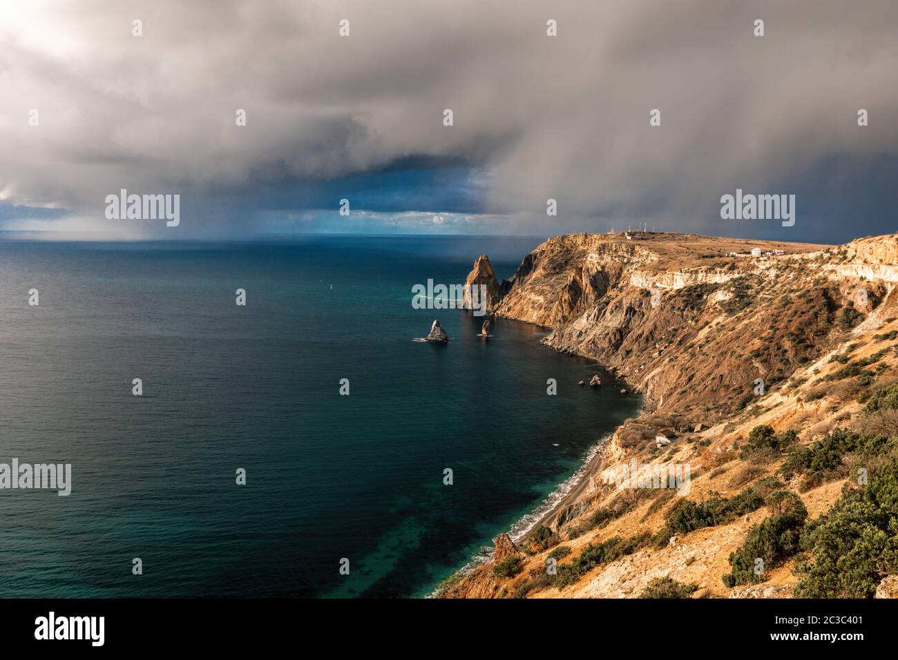 Rocky cliff against the stormy sky at the seashore. Landscape on the rocky shore of the Fiolent in Crimea. Storm approaching fog and gray skies with a Stock Photo