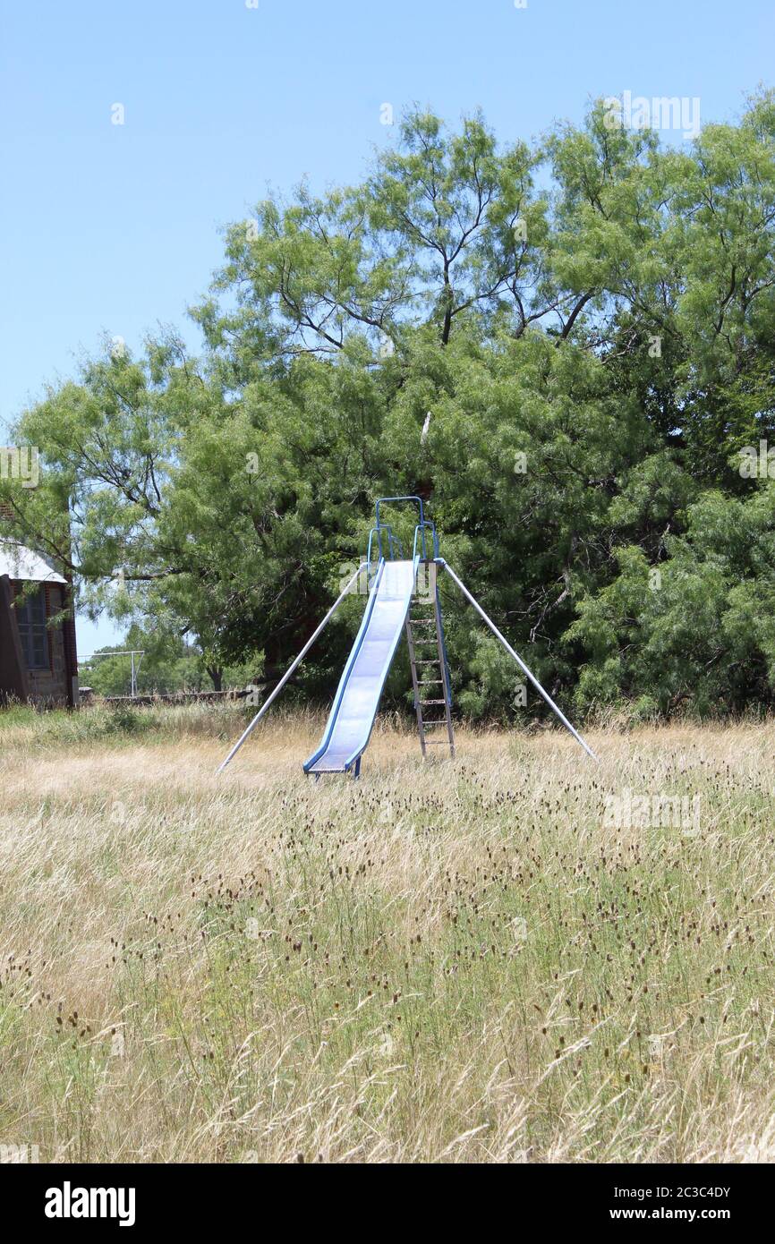 Hot slide in the summer sun behind a school in MIllersview Texas, USA Stock Photo