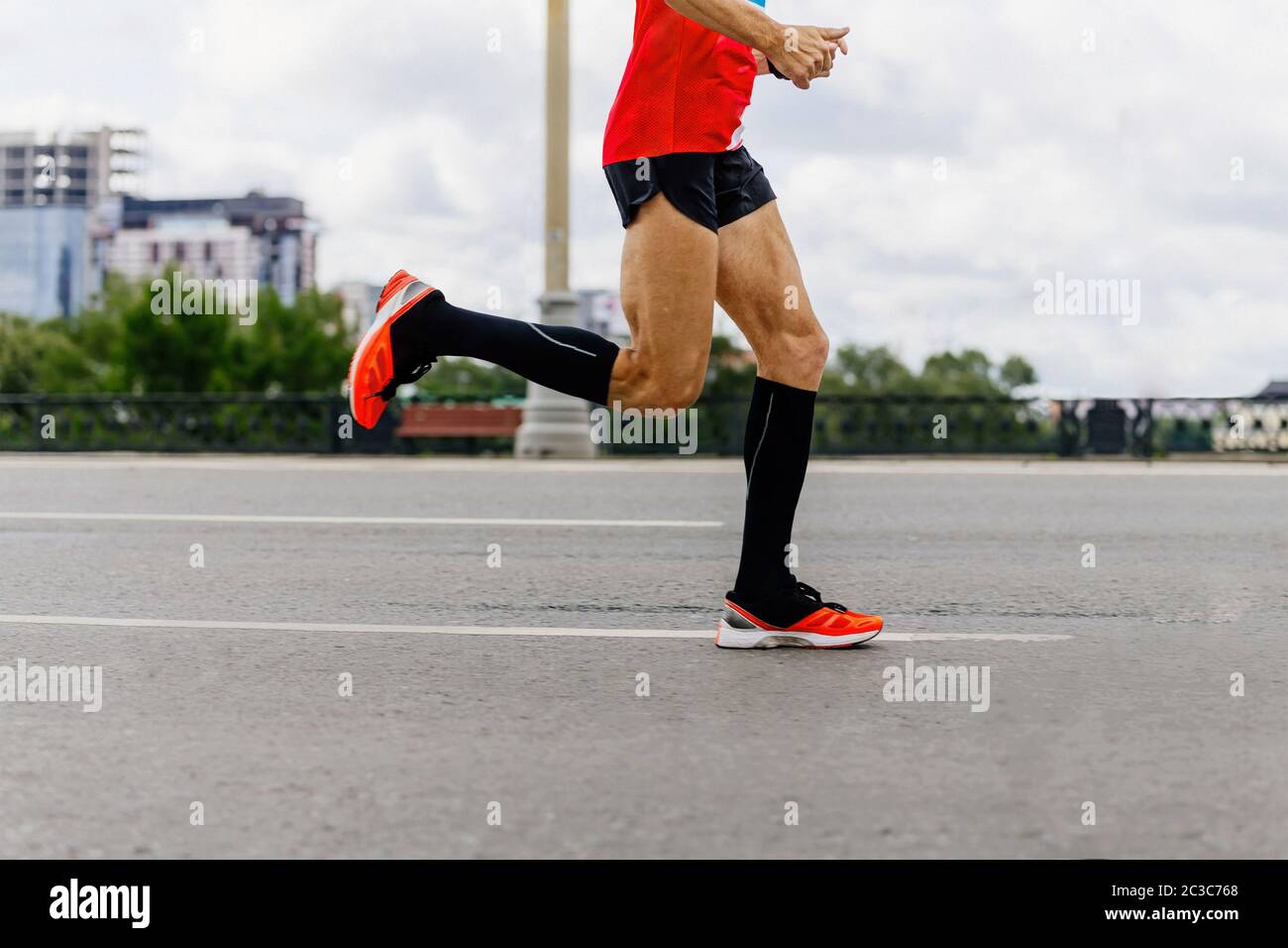 man runner in black compression socks run city marathon Stock Photo