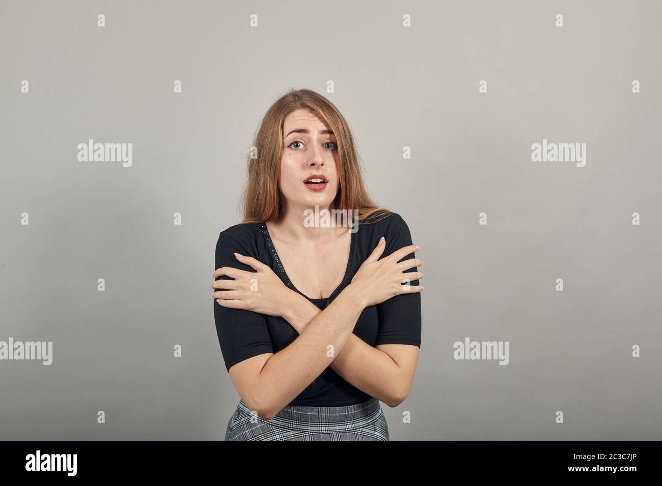 Hugging herself to warm while feeling cold arms crossed fear expression