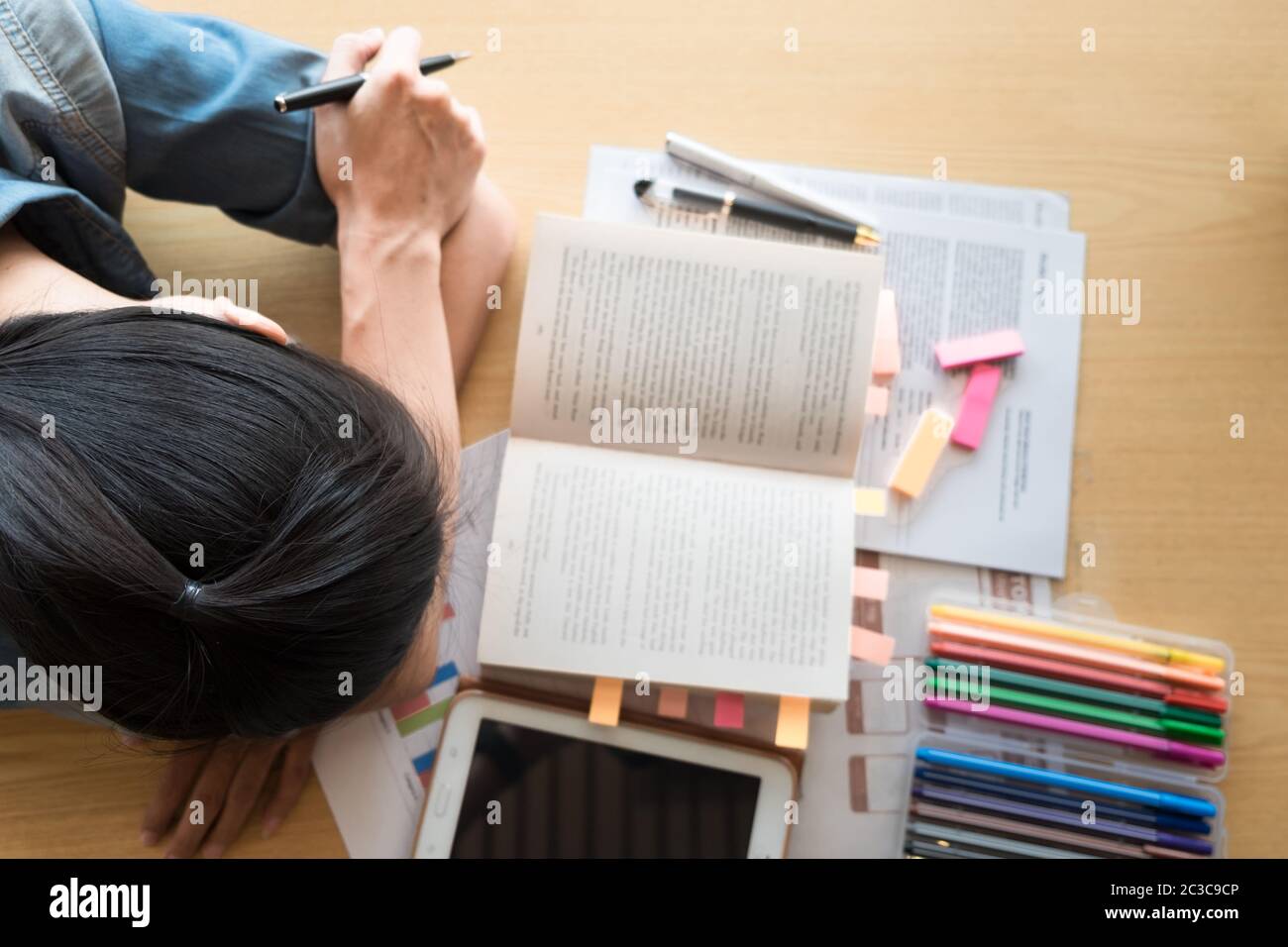 Tired student girl sleeping on the books in the library Stock Photo - Alamy