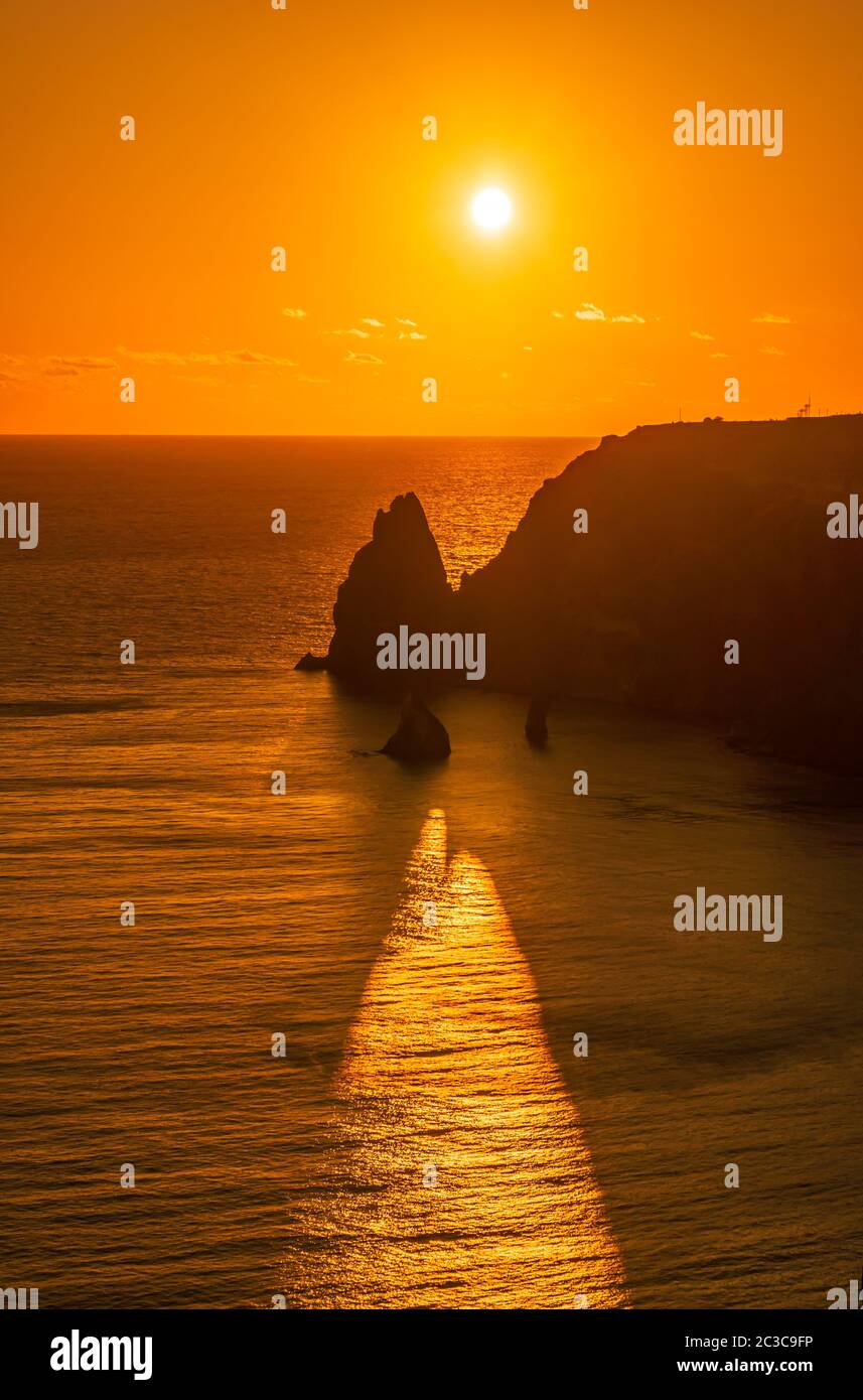 A red burning sunset with the silhouette cape Fiolent a cliff over the ...