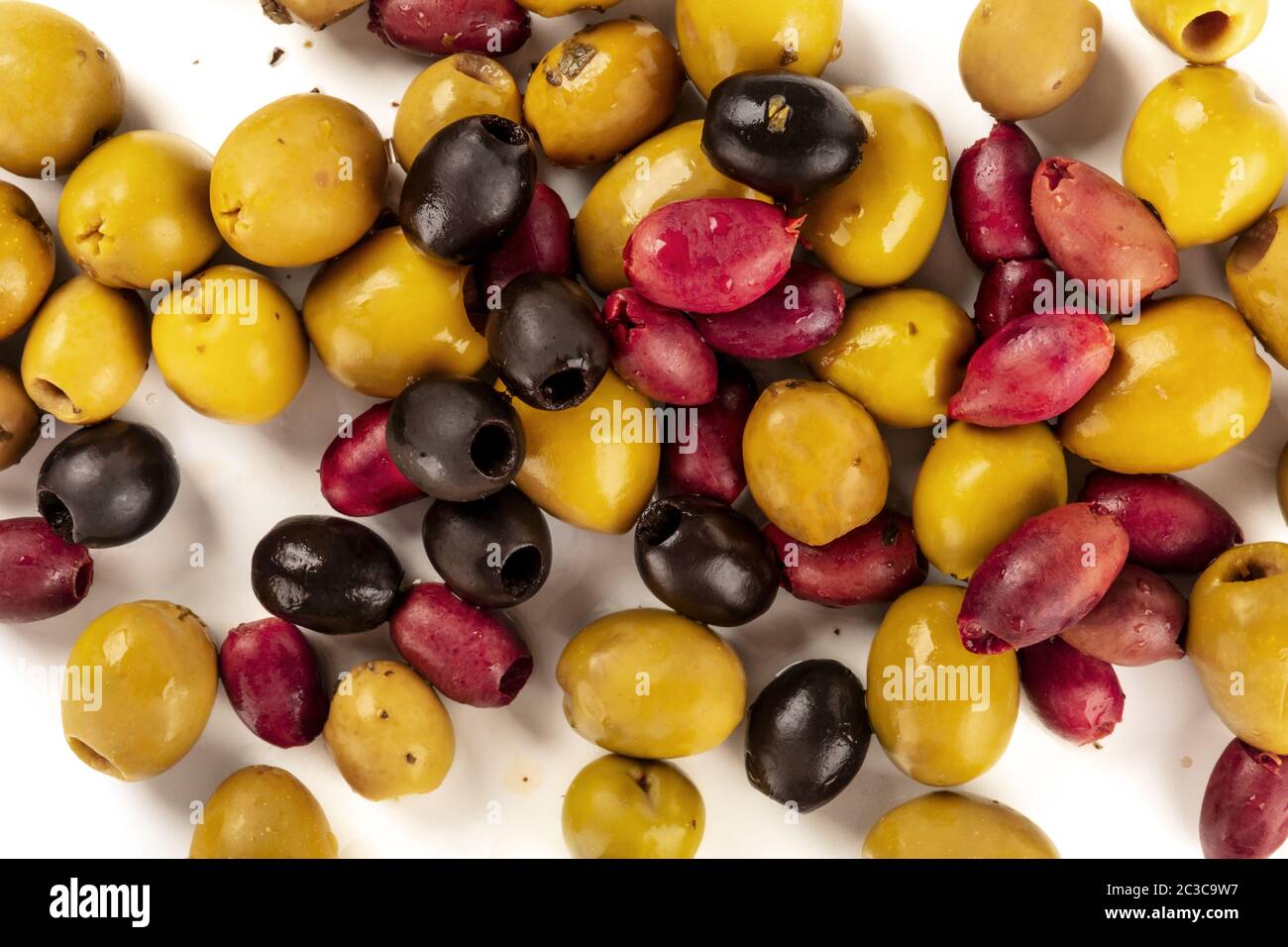 Many different olives, green, black and red, shot from the top on a white background Stock Photo