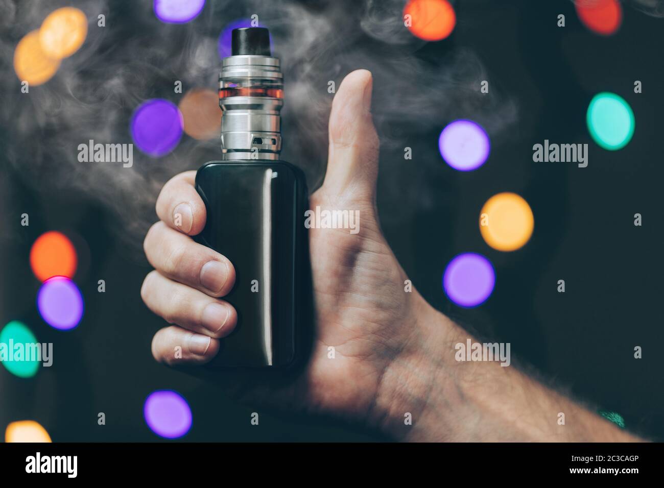 Vaping flavored e-liquid from an electronic cigarette Stock Photo