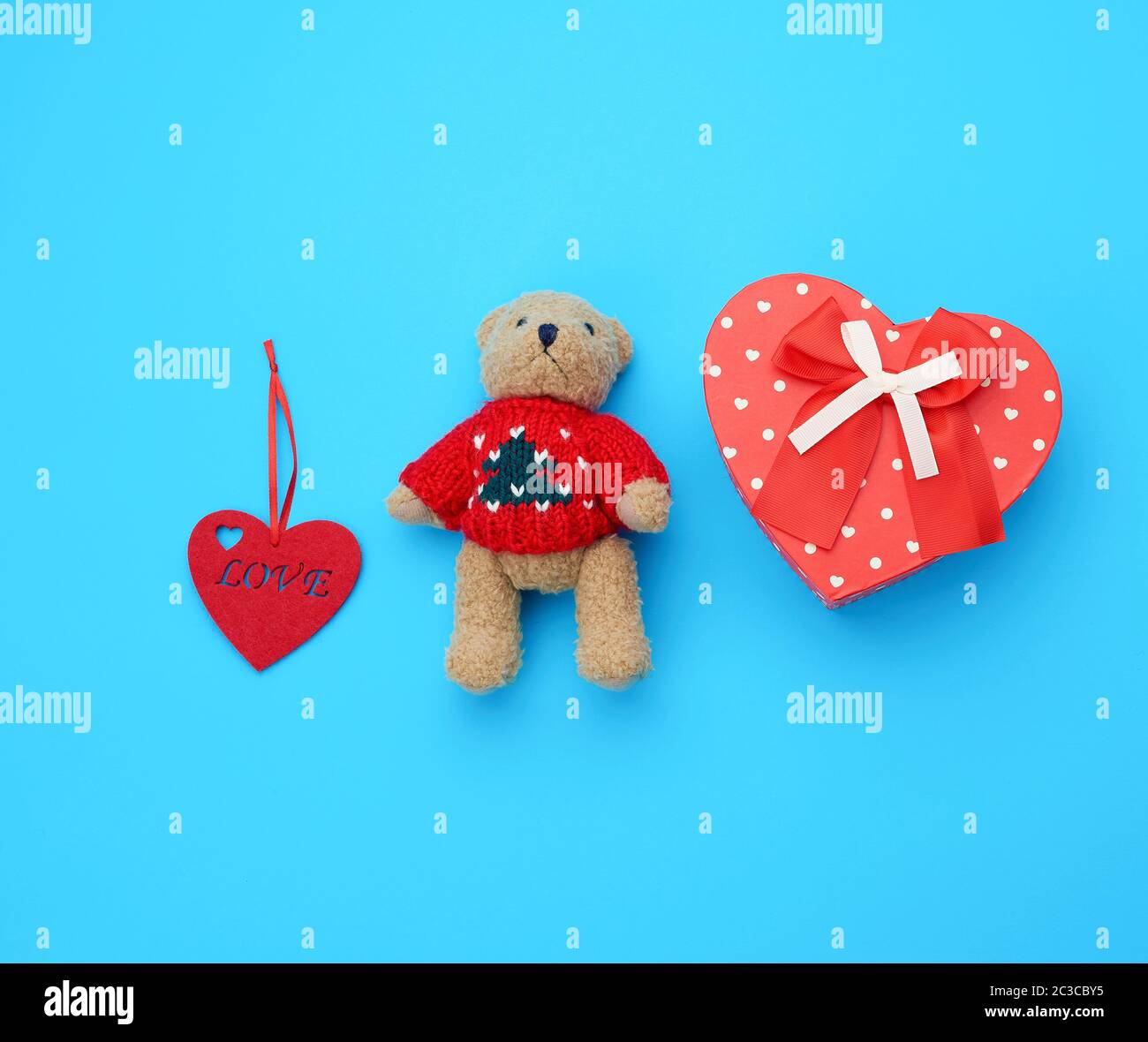 red cardboard box in the form of a heart and little brown teddy bear on ...