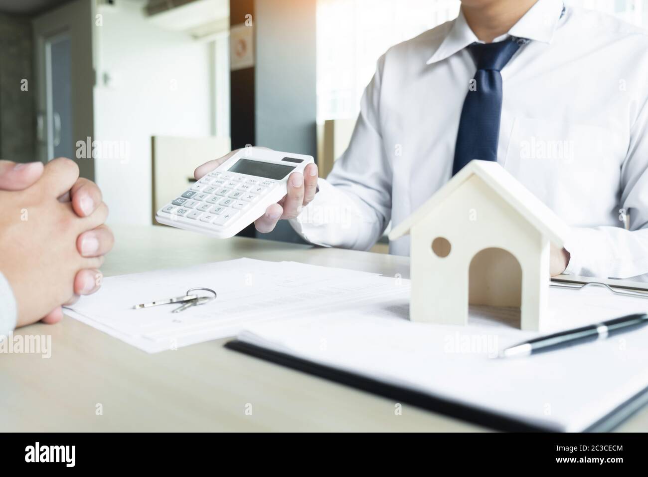 Real estate agent showing the purchase price on a calculator to his client Stock Photo