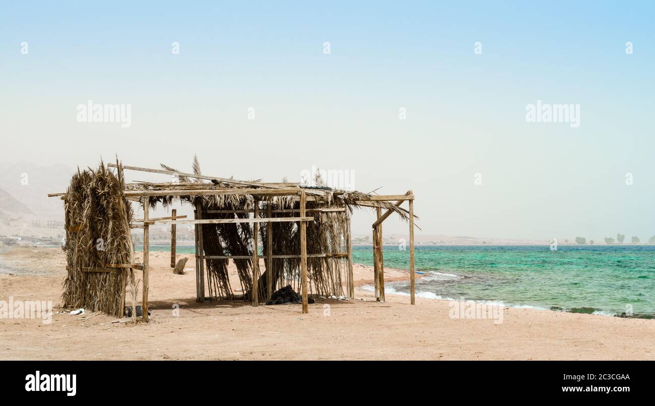 palm tree hut with garbage on the shores of the Red Sea in Egypt Dahab Stock Photo