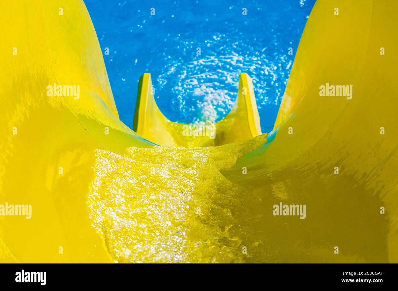 water flowing on a bright yellow hill on the background of the black pool Stock Photo
