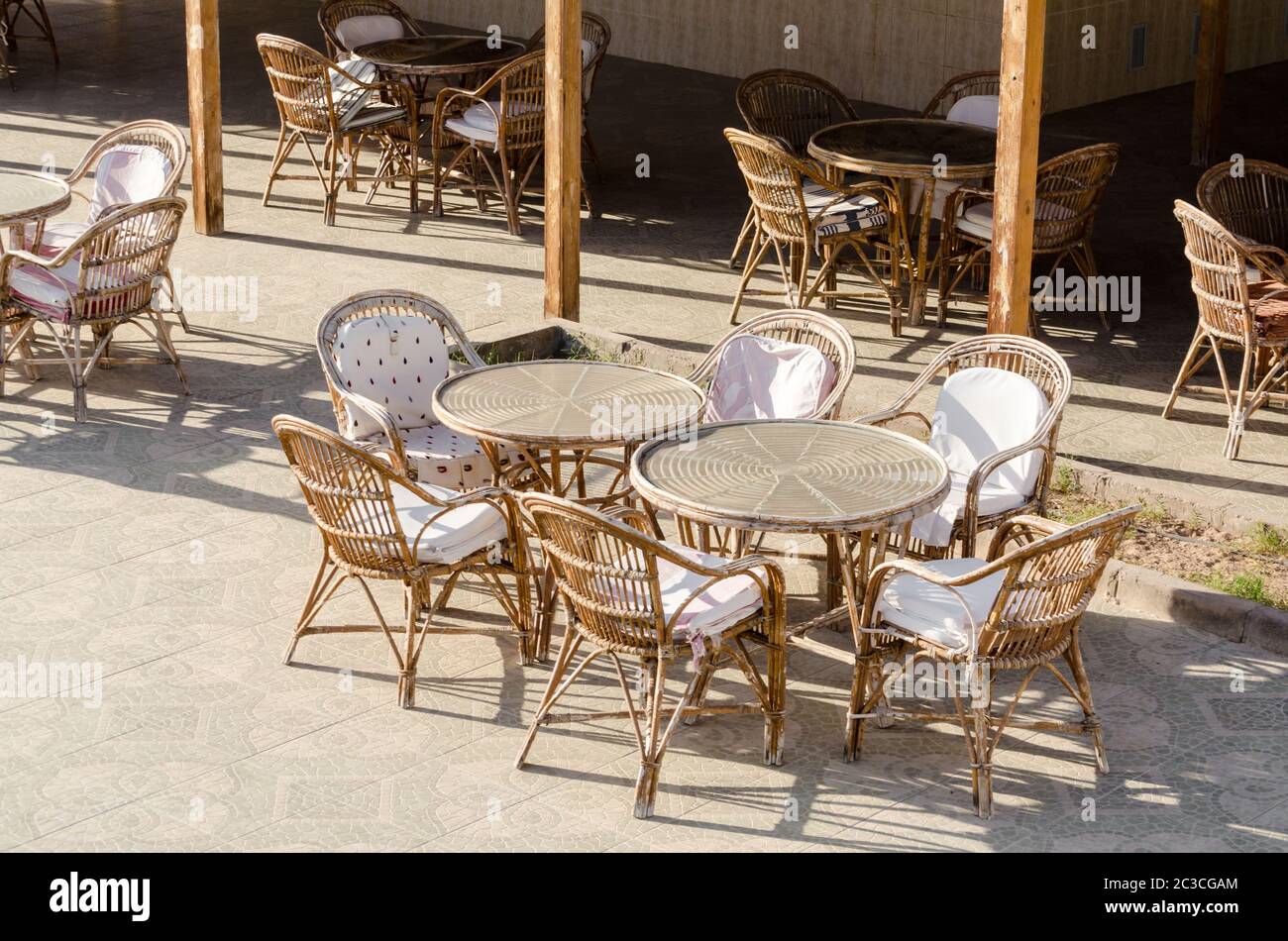 wooden chairs and round tables in an empty hotel cafe in Egypt Dahab South Sinai Stock Photo