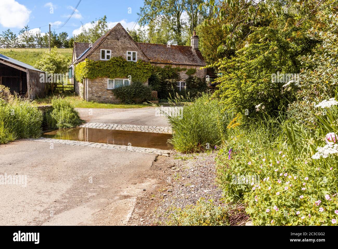 A cottage by the ford in the Cotswold village of Middle Duntisbourne, Gloucestershire UK Stock Photo