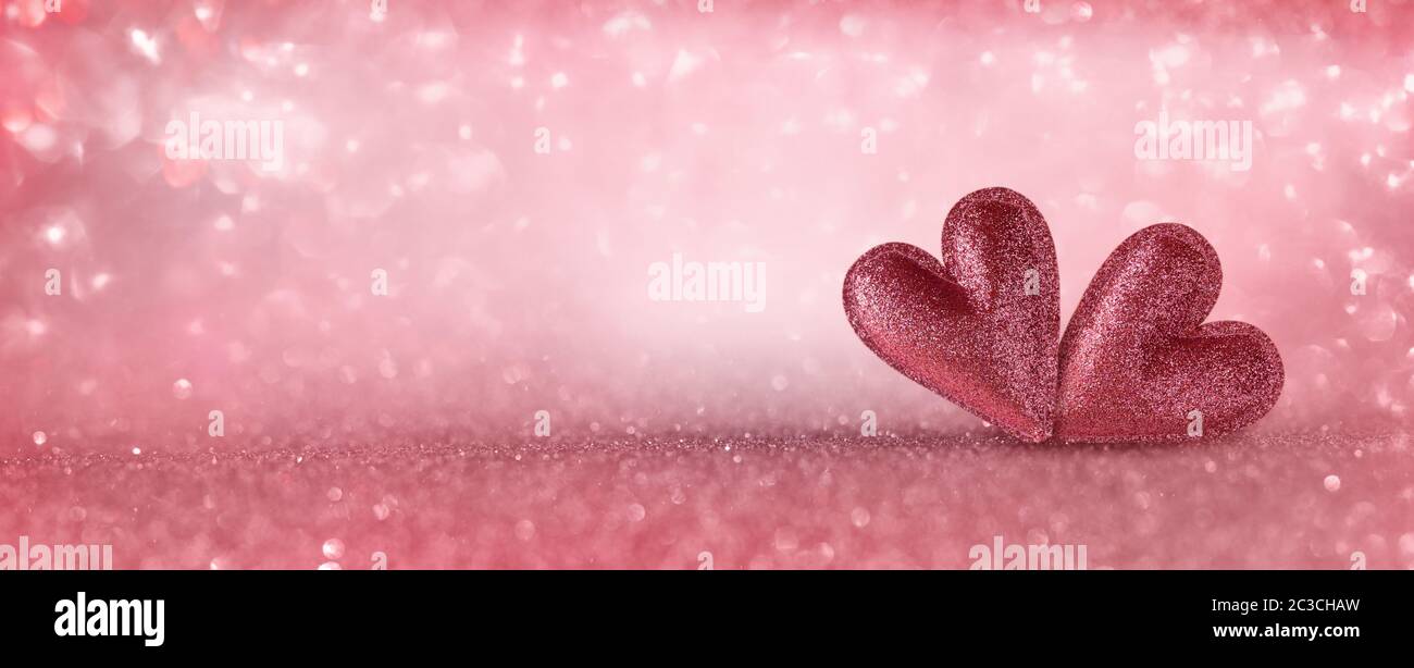 Two hearts for a love concept. Pink background with bright glitter and ...