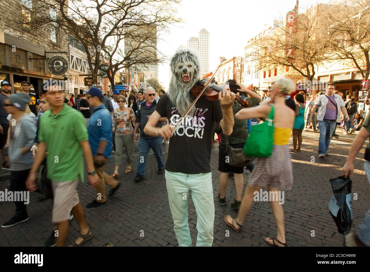 Austin, Texas USA, March 2013: Eccentric white male wearing a werewolf mask plays the violin outdoors in downtown Austin during the annual South by Southwest musical festival that draws thousands of music fans to the city. ©MKC/Bob Daemmrich Photography, Inc. Stock Photo