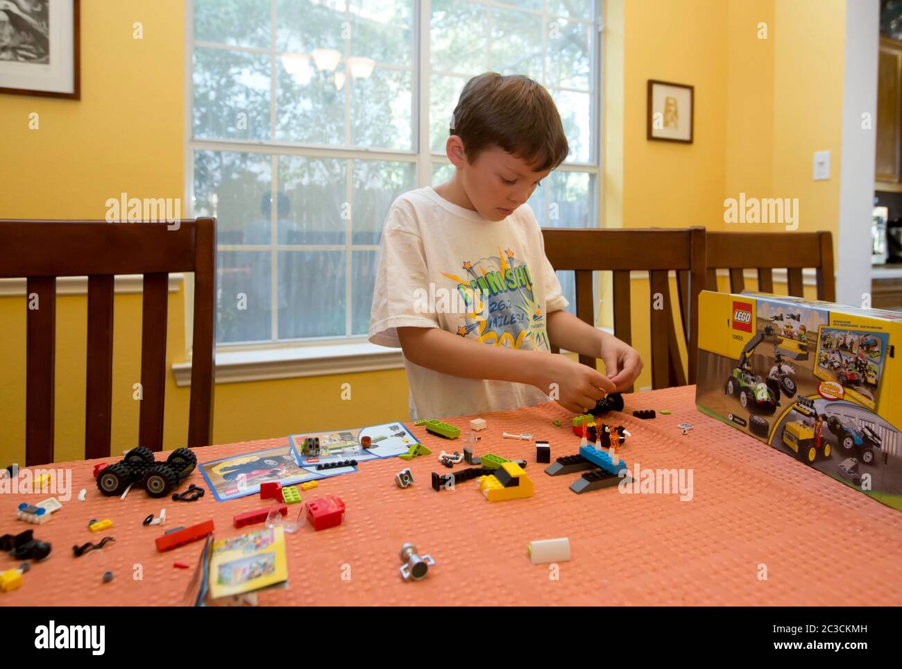 Austin Texas USA 2013 Seven year old Mexican American boy figures out how to put together a set of Legos building blocks at home. Marjorie Kamys Cotera Daemmrich Photography Stock Photo Alamy